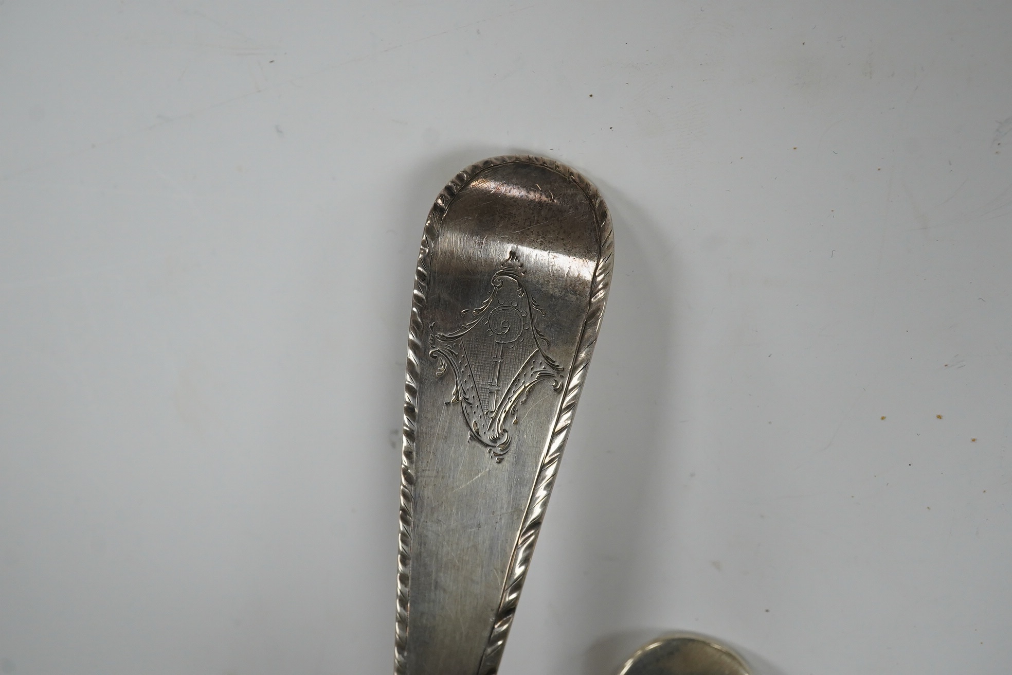 An early George III silver Old English feather edge pattern soup ladle, George Baskerville, London, 1766, together with a Victorian Scottish silver sauce ladle, 6.1 oz. Condition - poor to fair